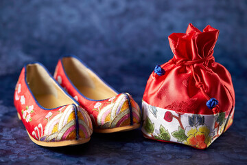 Traditional shoes and gifts on Korean script background 