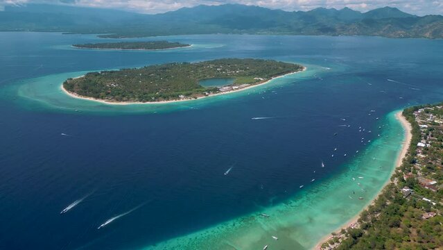 panoramic view of Gili islands in Indonesia.
shore of Gili T beach, Gili Menu in the middle and Gili Air in the back with Lambok mountains in the background.