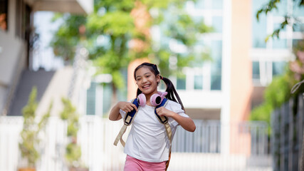 Back to school. Cute Asian child girl with a backpack running and going to school with fun