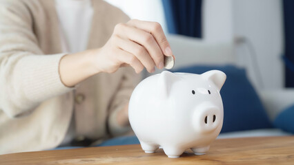 Asian woman putting coin in piggy bank. Save money and investment concept