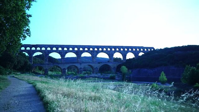 roman historical aqueduct with many celia stone arches over a river in france