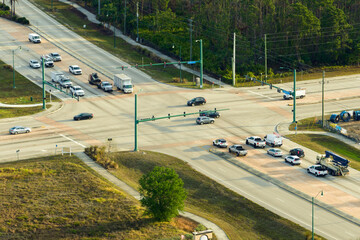 Top view of wide road with moving cars at intersection with traffic lights. City transportation in...