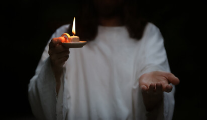 Resurrected Jesus Christ holding a lamp in his hand and extending his arms leading to the light,...