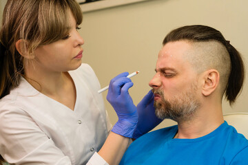 Fototapeta premium Marking face man before anti-aging treatment