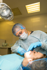 Dental surgeon examines patient's mouth