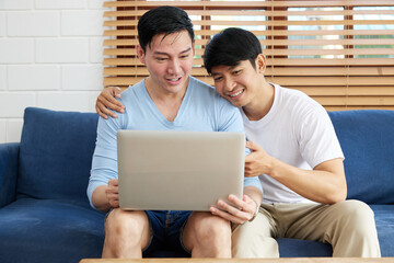 Fototapeta premium LGBT gay couple using laptop computer on sofa