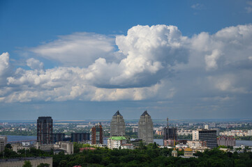 Beautiful cumulus clouds in the blue sky over the city.