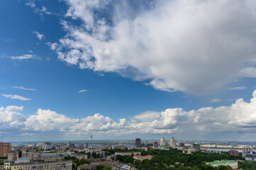 Fototapeta premium Beautiful cumulus clouds in the blue sky over the city.