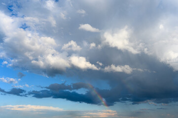 Naklejka na ściany i meble Amazing bright rainbow in a beautiful blue cloudy sky after rain and thunder