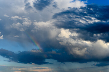 Naklejka na ściany i meble Amazing bright rainbow in a beautiful blue cloudy sky after rain and thunder