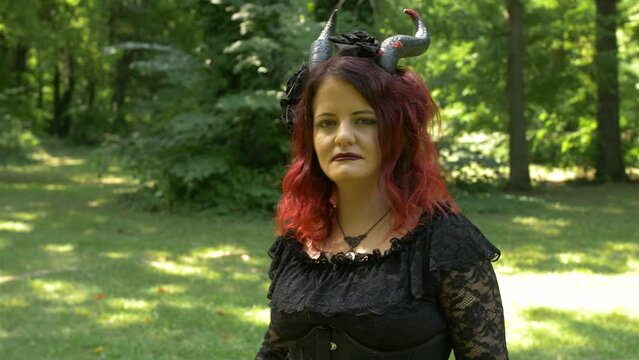 Till Up from Succubus cosplay girl in the forest moving toward you, Medium Shot Slow Motion.