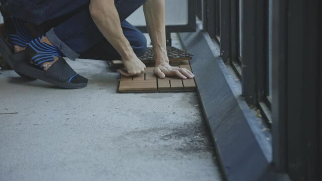 Unrecognizable Man Placing Interlocking Deck Tiles At The Porch. Close Up