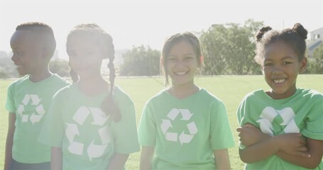 Portrait of happy diverse schoolchildren with recycling tshirts at stadium in slow motion