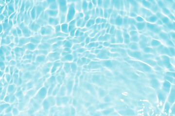 Fototapeta premium Blue water with ripples on the surface. Defocus blurred transparent blue colored clear calm water surface texture with splashes and bubbles. Water waves with shining pattern texture background.