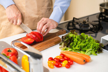 トマトを切る若い男性　料理イメージ	
