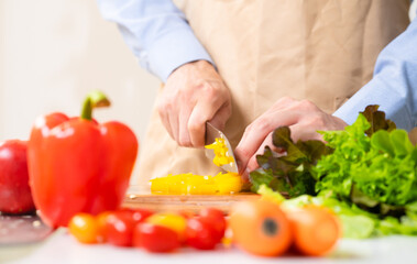 パプリカを切る若い男性　料理イメージ	
