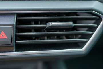 Zbliżenie na kratkę nawiewu klimatyzacji w samochodzie osobowym wnętrze kabina  - obrazy, fototapety, plakaty