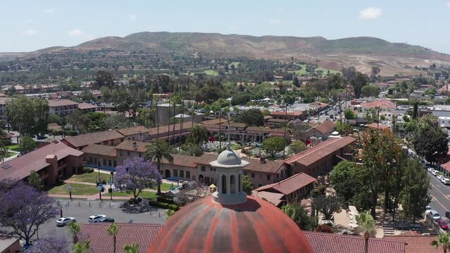 Close-up rising aerial shot above the Mission Basilica dome towards the Mission San Juan Capistrano in California. 4K
