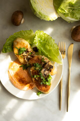 zrazy with mushrooms and sauce on a plate top view. cutlets with mushrooms and cabbage on a decorated table close-up.