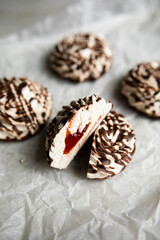 white zephyr covered with chocolate icing close-up. halves of zephyr with jam inside macro