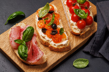 Sandwich set of bruschetta with juicy tomatoes, cheese and prosciutto