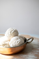 white zephyr in a copper bowl close-up. zephyr on a white background macro.