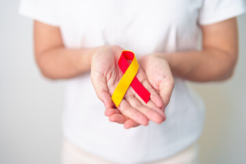 woman holding Red and Yellow ribbon. World hepatitis day awareness month, 28 July, Liver cancer,...