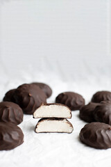zephyr in chocolate glaze top view. chocolate zephyr close-up. halves of zephyrs in chocolate on a white background macro	
