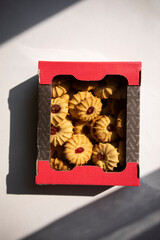 cookies with jam in the middle. shortbread cookies in a box top view. supermarket cookies in the package. a set of cookies in a package on a white surface with a shadow from the sun.