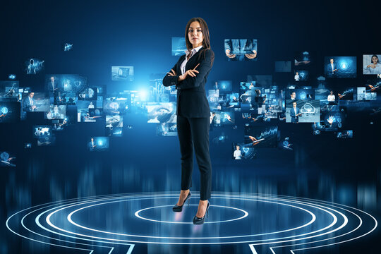 Attractive young european businesswoman standing on abstract teleport with metaverse images on blurry blue background. Digital world and virtual reality concept.