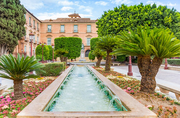 Palm trees, flowers and fountain on the glorieta de espana square in Murcia, Spain