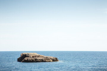 Fototapeta na wymiar small rock island just beyond the shoreline