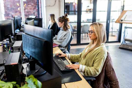 Young businesswomen working on desktop PC in office