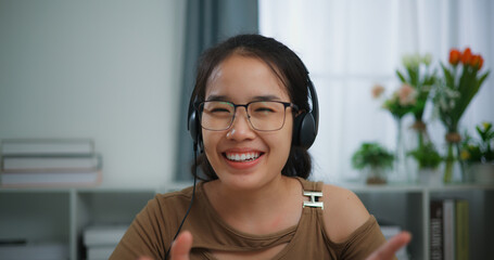 Young Asian woman wearing glasses using a laptop on a desk