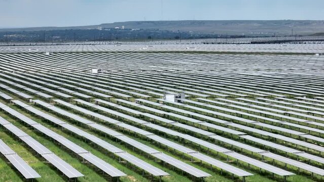 Sprawling solar farm. Aerial establishing shot of rows of photovoltaic cells forming array.