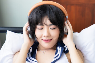 Asian Woman with Headphones Listening to Relaxing Music