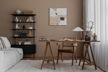Creative composition of warm and cozy workspace interior with mock up poster frame, wooden desk, modular sofa, black rack, rattan chair, stylish lamp and personal accessories. Home decor. Template.