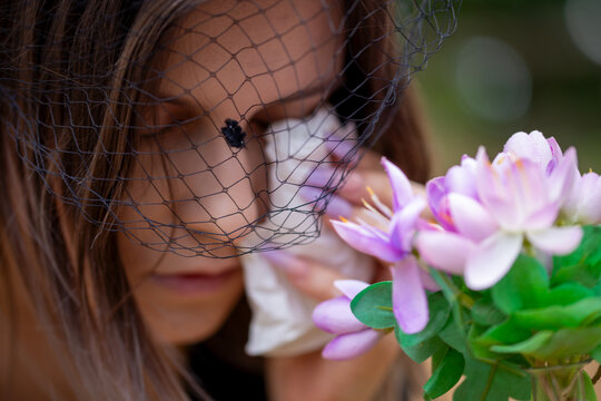 Nahaufnahme einer trauernden jungen Frau mit Trauerschleier  (Symbolbild, model released)