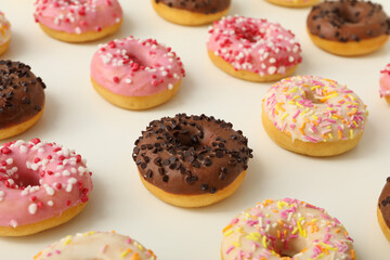 Chocolate, white and pink donuts on white background