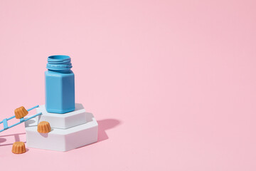 Blue jar on white blocks and stepladder on pink background, space for text