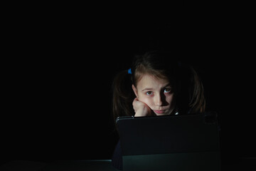 Lack of sleep as a result of studying at night may impair children's mood, increase stress and anxiety levels and decreased cognitive abilities. Young girl studies online at night. Copy space for text