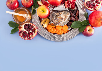 A dish with a New Year's treat for the holiday Rosh Hashanah. pomegranate, honey, dates, apple...