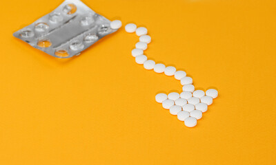 Medical concept - some pills flow out of the blister pack in the shape of an arrow over orange background.
