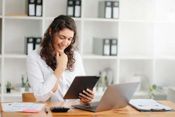 businesswoman working in the office with working notepad, tablet and laptop documents .