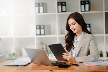 Working woman concept a female manager attending video conference and holding tablet, smatrphone and  cup of coffee