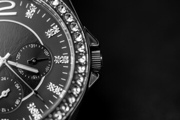 Luxury wrist watch full of diamonds on black with copy space. Analog wrist watch close up picture....