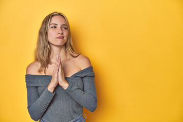 Elegant blonde on yellow backdrop, making up plan in mind, setting up an idea.