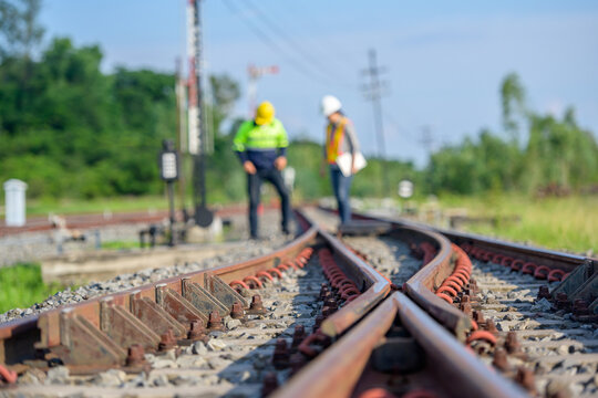 Selective focus on railway line Workers or engineers who maintain railway tracks Check the switchgear building process and check the work in the train station. - Powered by Adobe