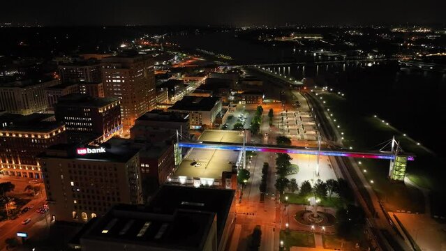 Davenport, Iowa pedestrian walkway lit up at night with drone video moving in.
