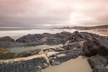 Sunset gives a purple glow to the coastline Saligo bay, Scotland.